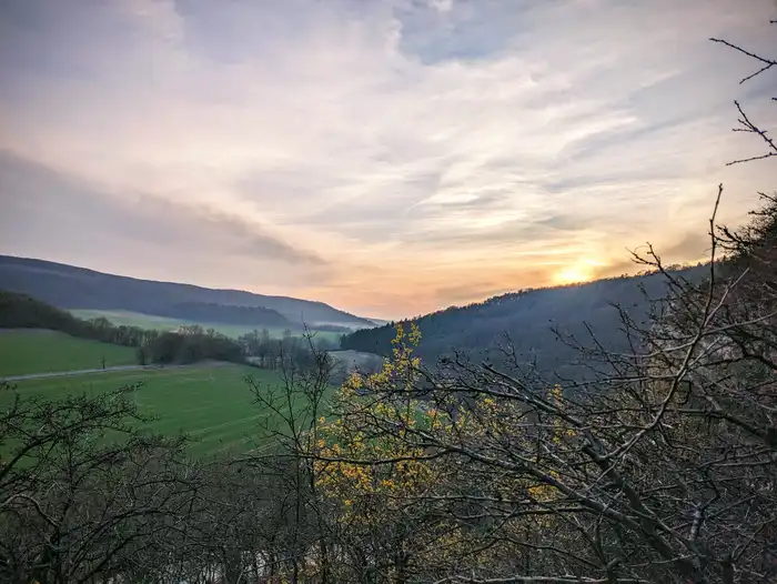 Foto: ein Blick in die Ferne: Wald und Hügel im Sonnenuntergang